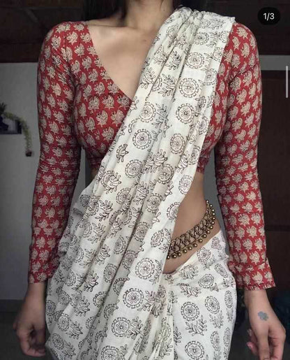 Person wearing a red and white patterned outfit with a white saree.