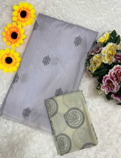 Gray fabric with black patterns and a matching pouch on a textured surface with flowers.