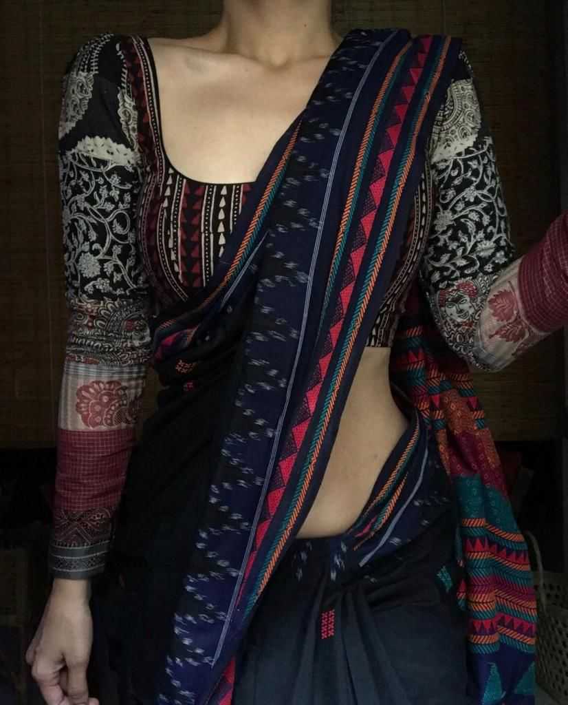 Person wearing a colorful patterned saree with a dark background