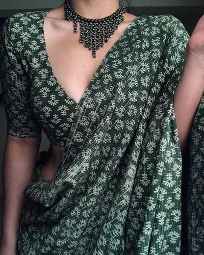 Green and white patterned saree with a deep neckline