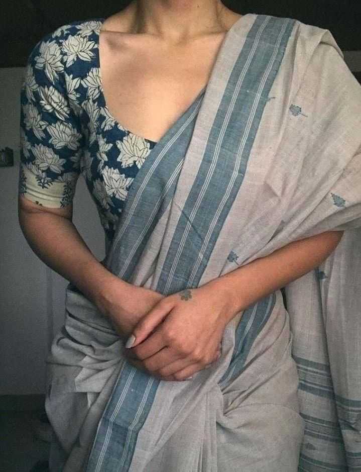 Person wearing a blue and white floral blouse with a matching saree.