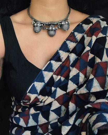 Person wearing a geometric-patterned saree with a necklace