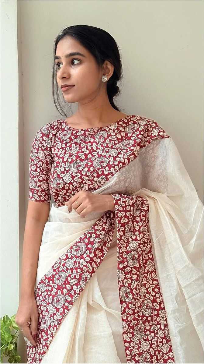 Woman wearing a red and white saree with a plain background