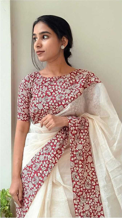 Woman wearing a red and white saree with a plain background