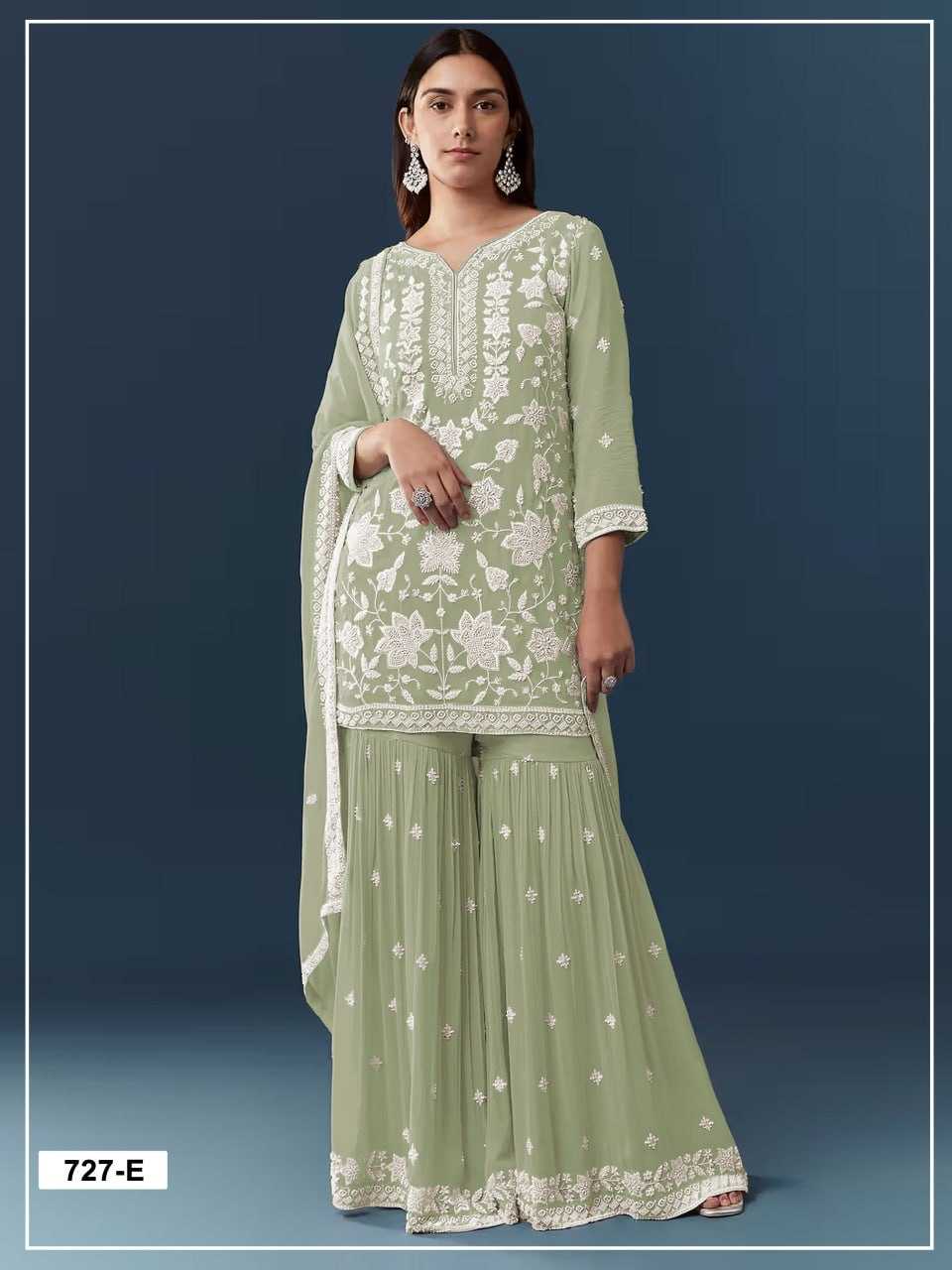 Woman wearing a light green traditional outfit with white embroidery on a dark blue background