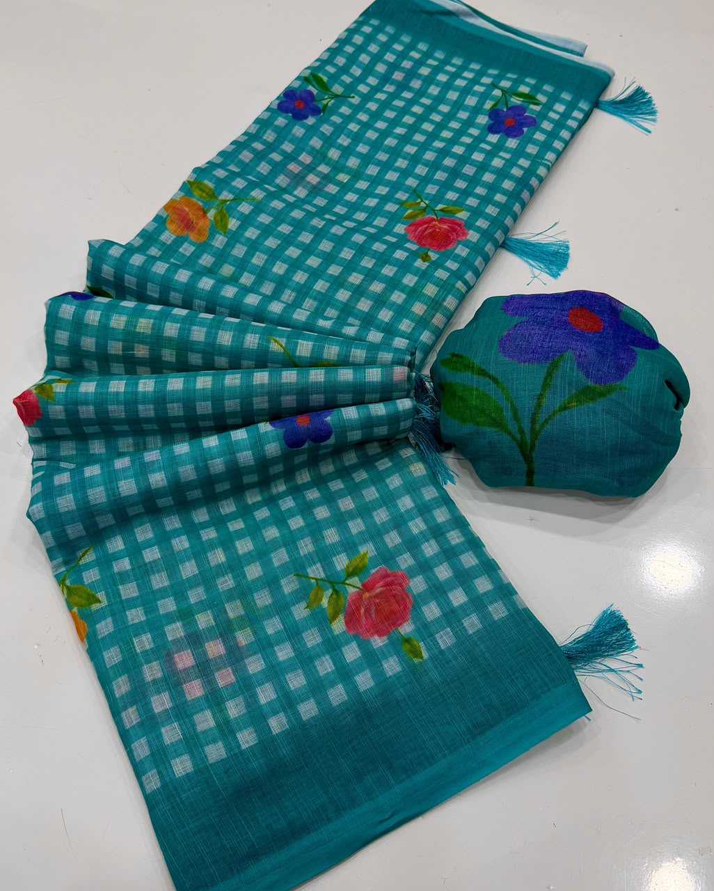 Turquoise checkered fabric with floral embroidery on a white background