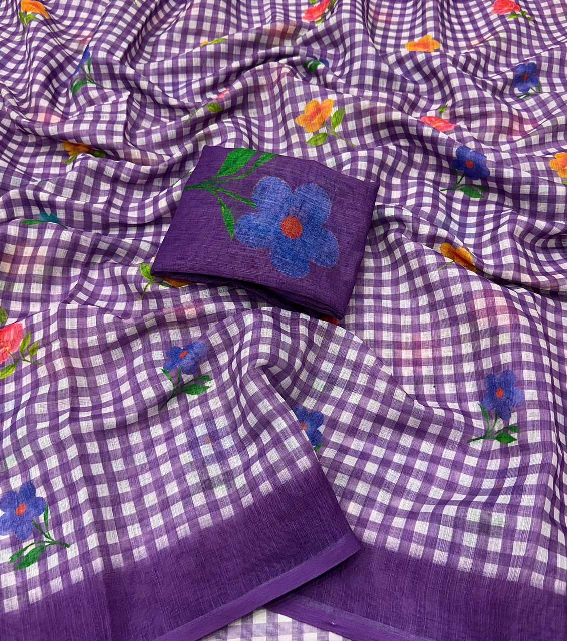 Purple and white checkered cotton saree with colorful floral embroidery and a matching purple border, displayed as a flat lay.