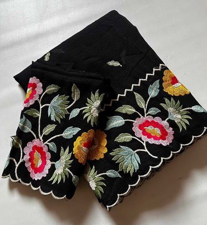 Black fabric with colorful floral embroidery on a white background