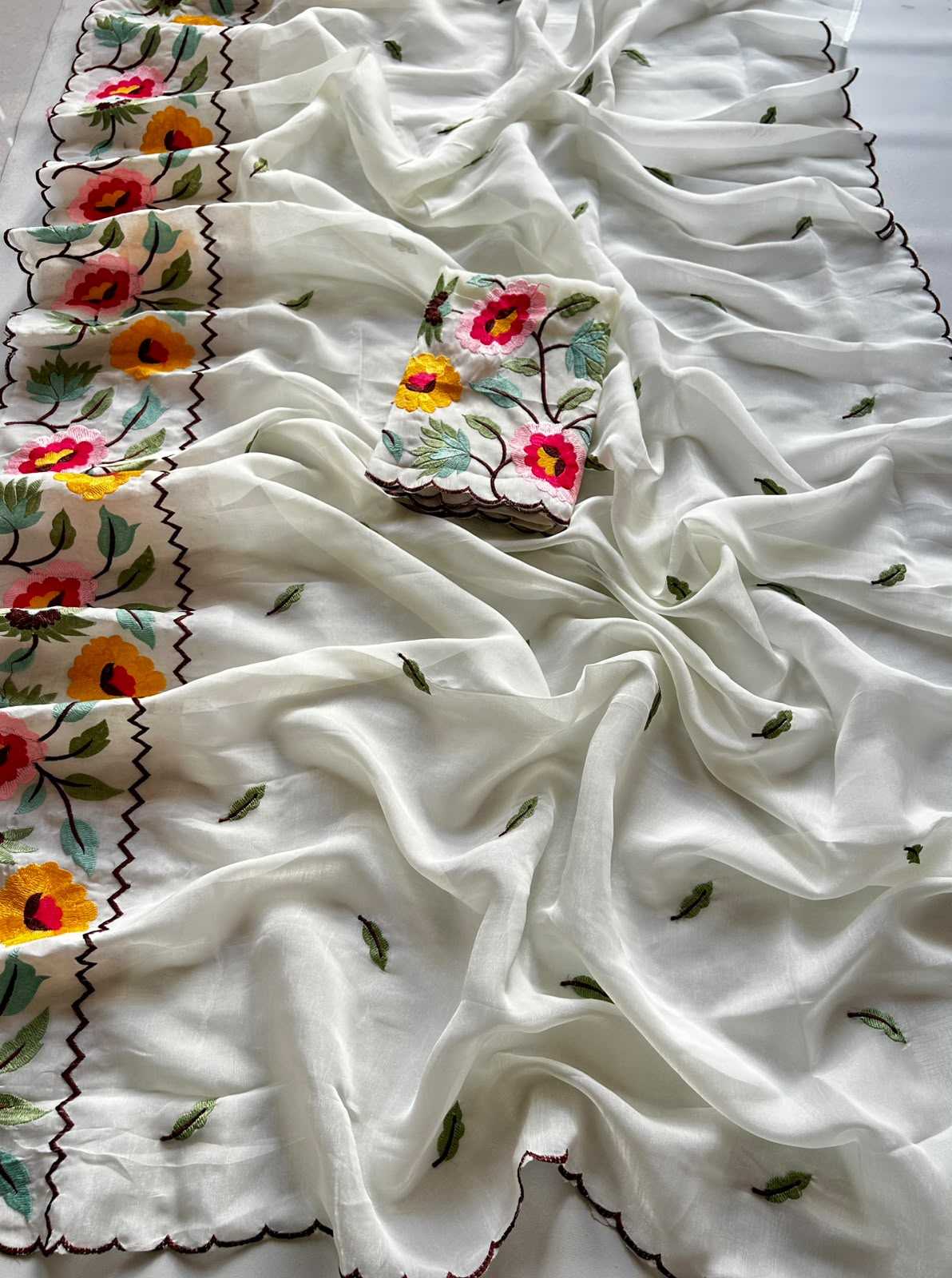 White fabric with colorful floral embroidery on a white background