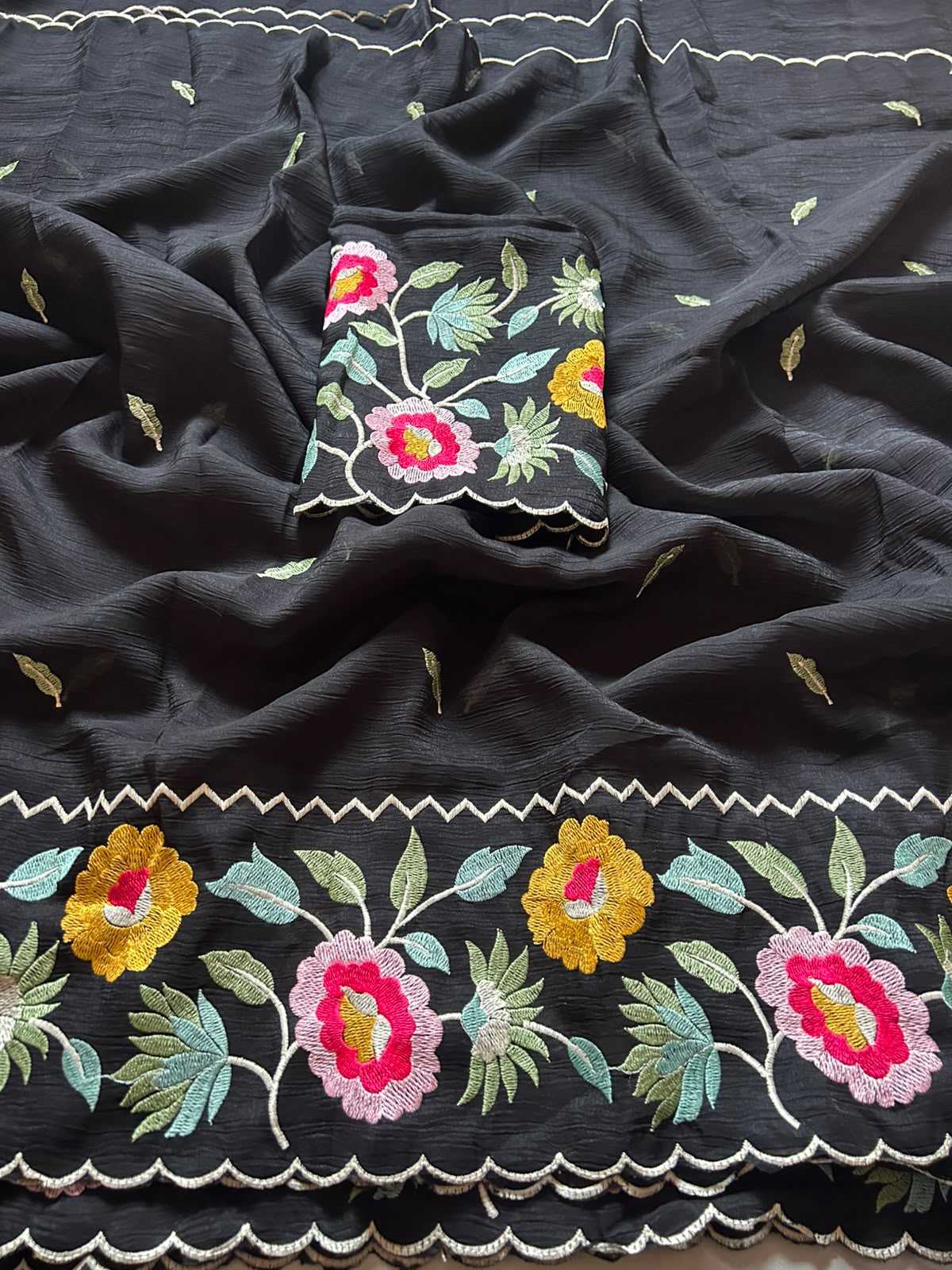Black fabric with colorful floral embroidery on a dark background