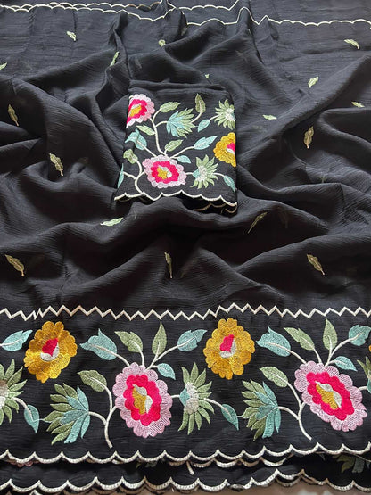 Black fabric with colorful floral embroidery on a dark background