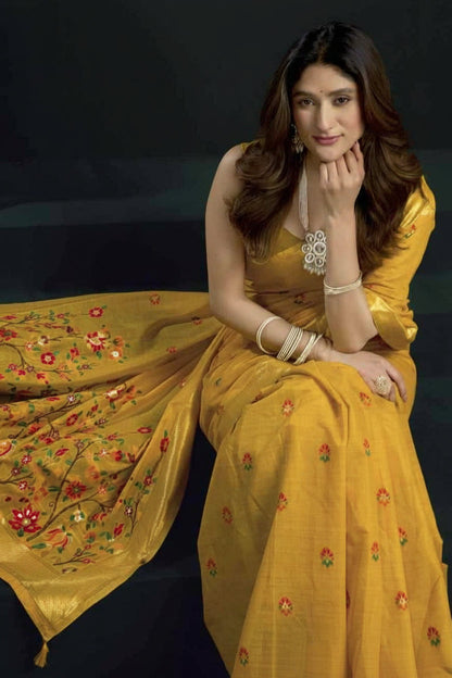 Woman in a yellow saree with floral patterns against a dark background, featuring the brand 'Gobuni'.