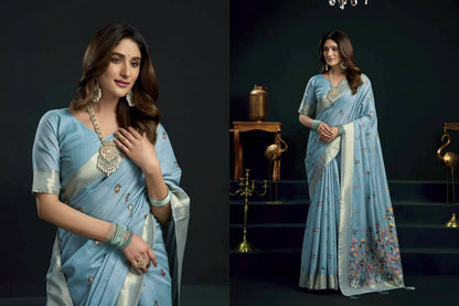 Woman wearing a light blue saree with a dark background, featuring the brand 'Gobuni'.