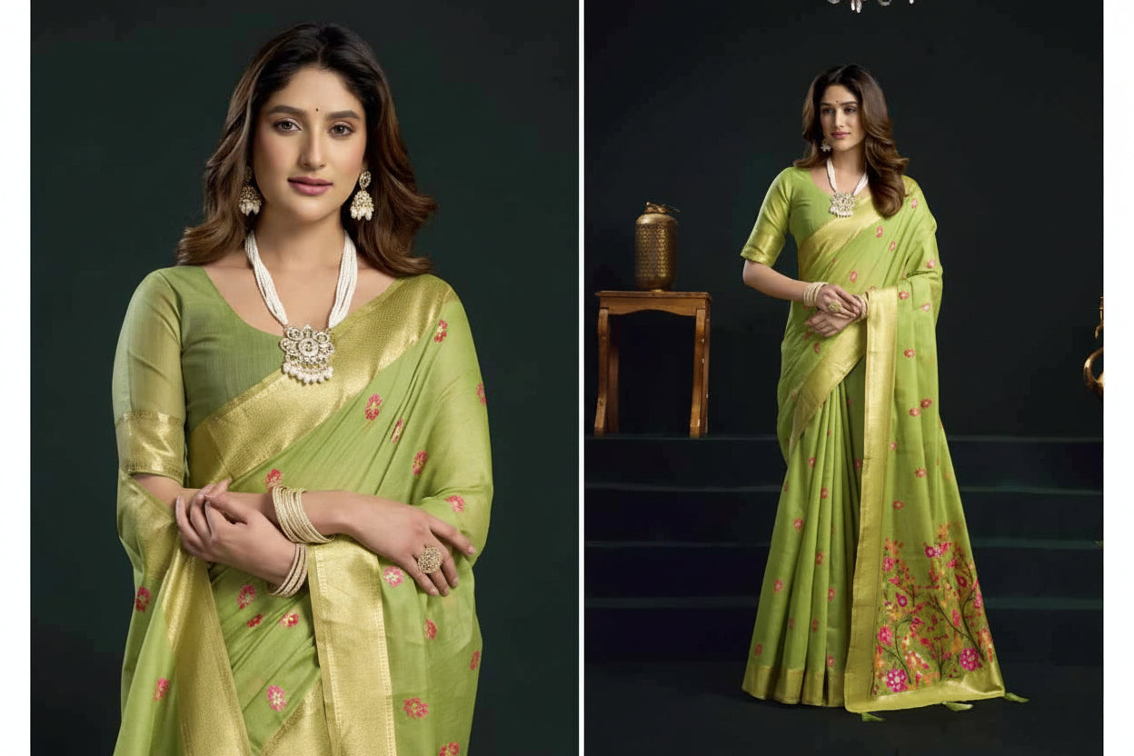 Woman wearing a green saree with floral patterns, standing against a dark background.