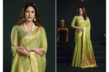 Woman wearing a green saree with floral patterns, standing against a dark background.