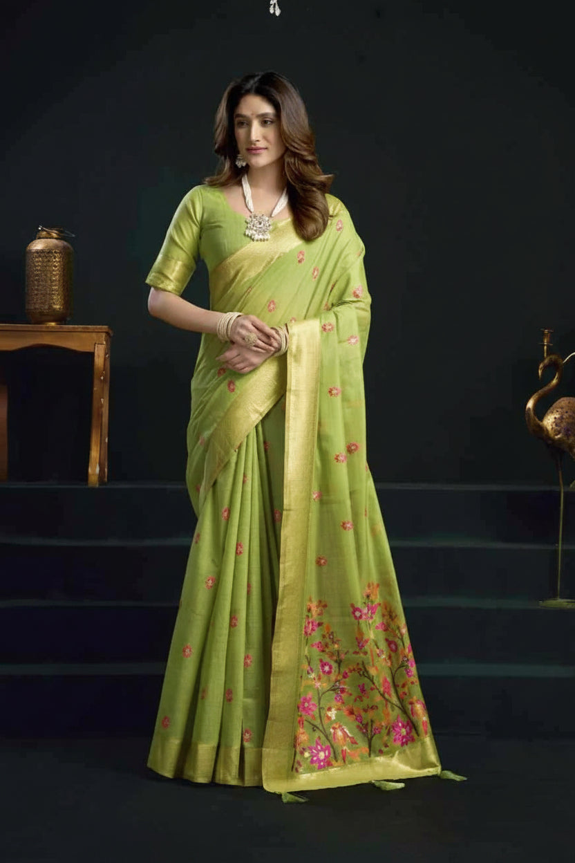 Woman wearing a green saree with floral patterns on a dark background, featuring the brand 'Gobuni'.
