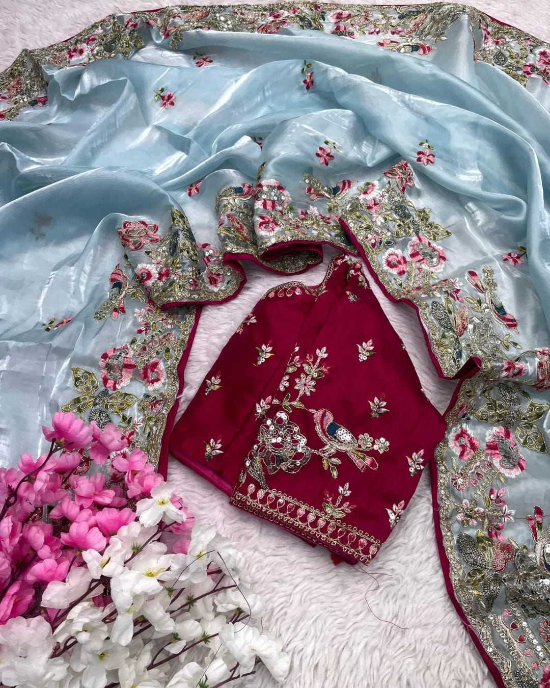 Embroidered red outfit with floral patterns on a light blue fabric background