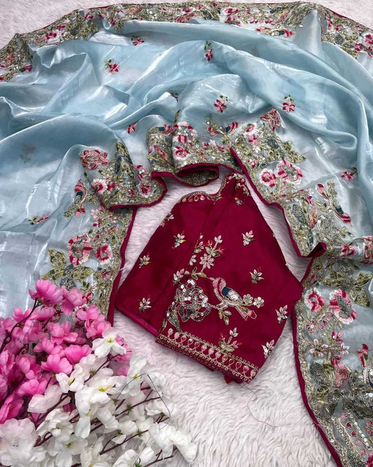 Embroidered red outfit with floral patterns on a light blue fabric background
