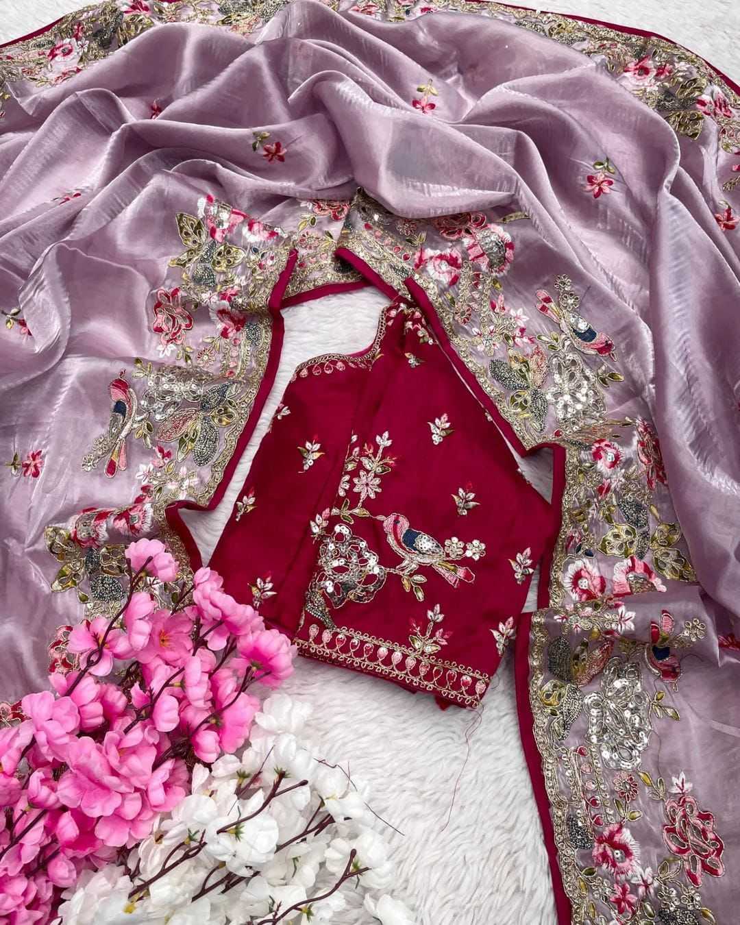 Red embroidered blouse with floral patterns on a pink fabric background