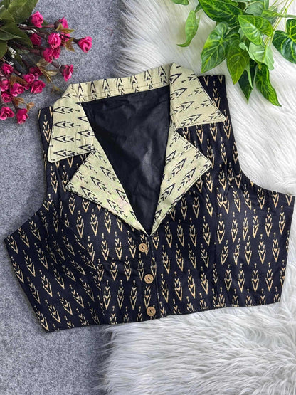 Black patterned vest with cream collar on a textured surface with flowers and leaves.