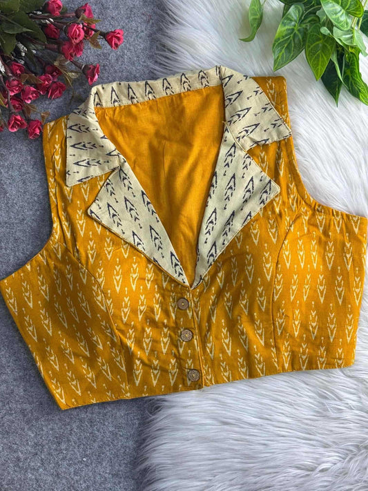 Yellow patterned shirt with a white collar on a textured surface with flowers and leaves.
