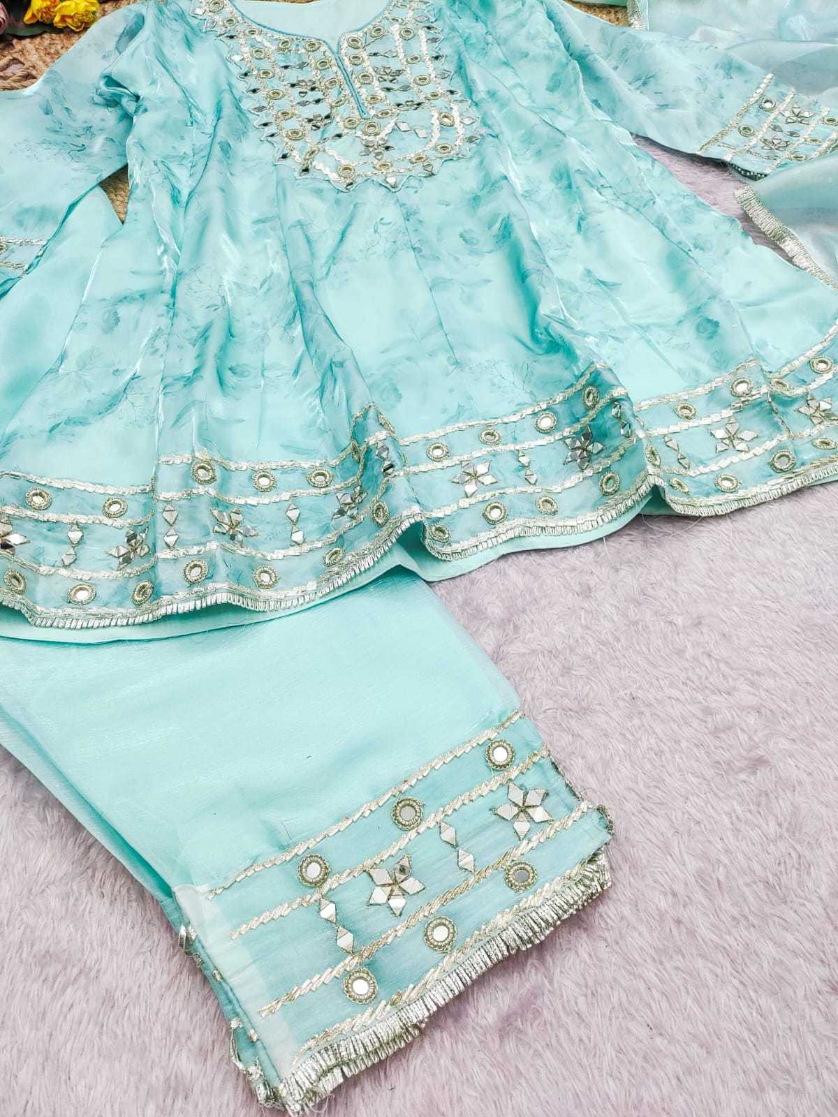 Light blue fabric with intricate white embroidery on a pink background