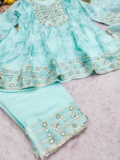 Light blue fabric with intricate white embroidery on a pink background