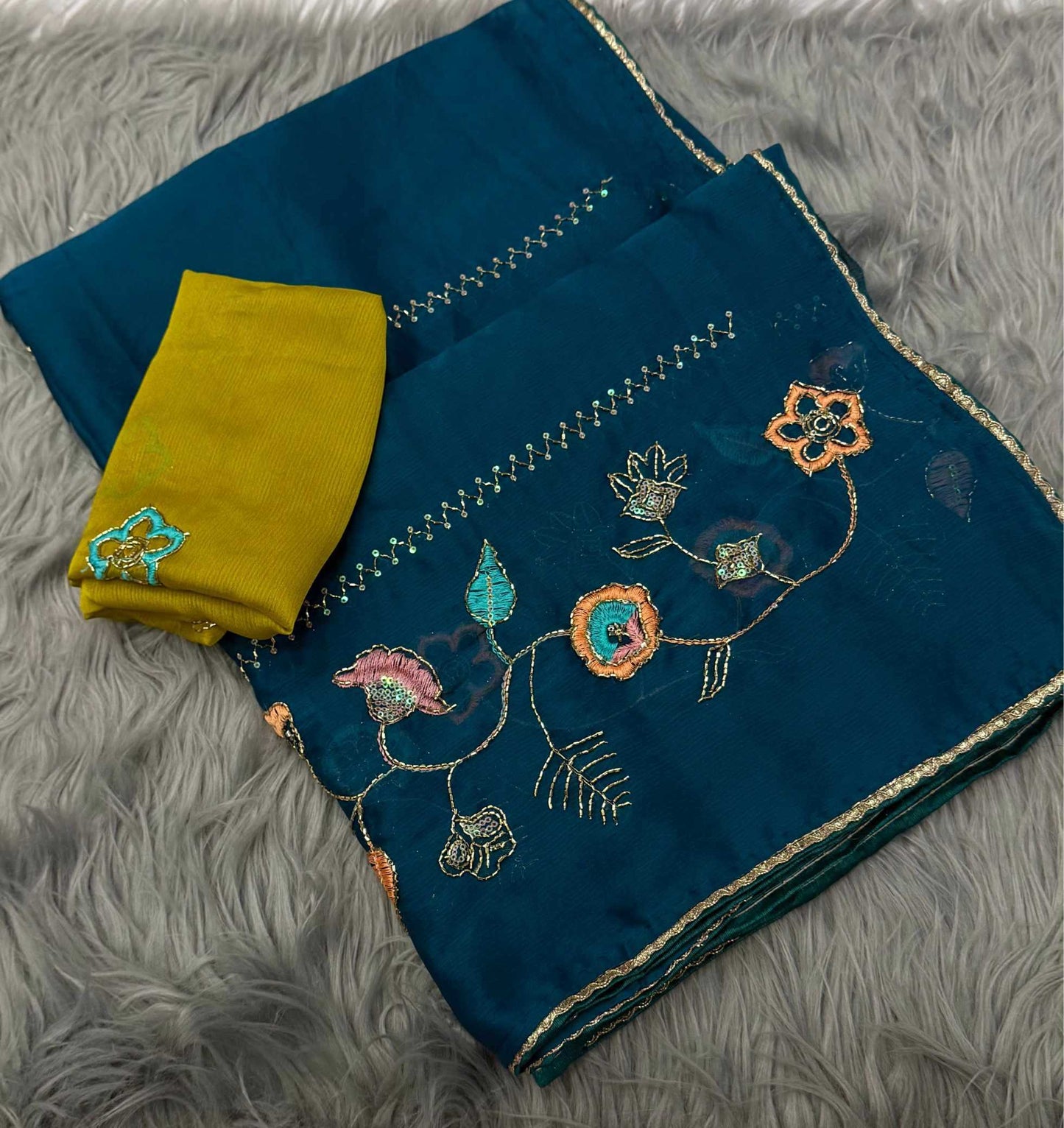 Blue embroidered fabric with a yellow pocket on a gray textured surface