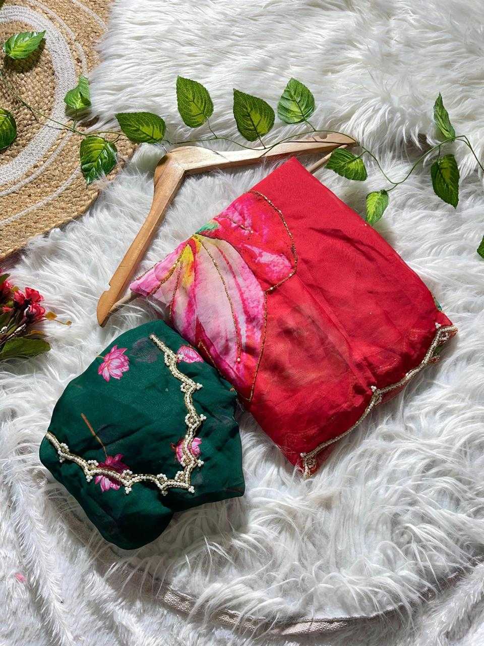 Two folded fabric accessories, one dark green with pink floral print and gold trim, and one red with pink floral print and gold trim, displayed on a white faux fur background with decorative leaves and a wooden hanger.