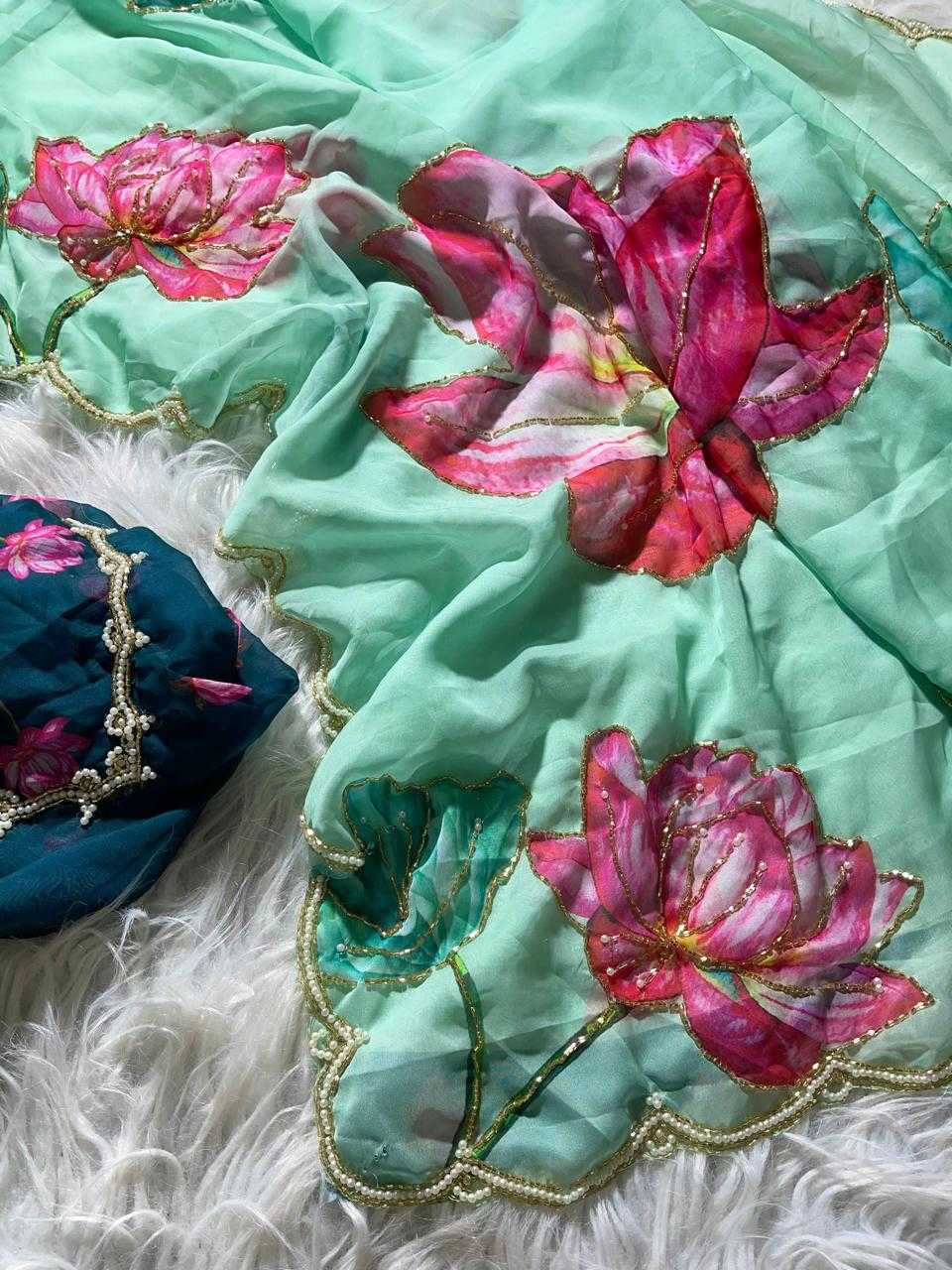 Turquoise fabric with pink floral embroidery on a white fluffy surface