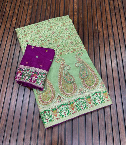 Green saree with paisley patterns and a purple blouse on a wooden surface