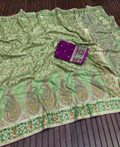 Green paisley patterned fabric with a purple pouch on a wooden surface