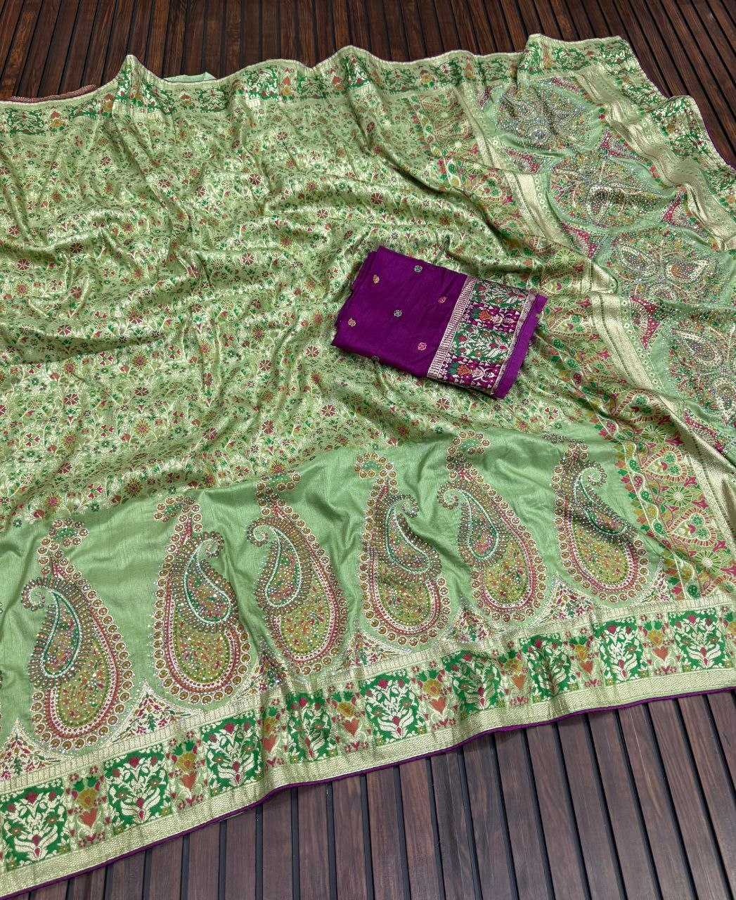 Green paisley patterned fabric with a purple pouch on a wooden surface