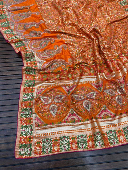 Decorative orange and green patterned fabric on a wooden surface