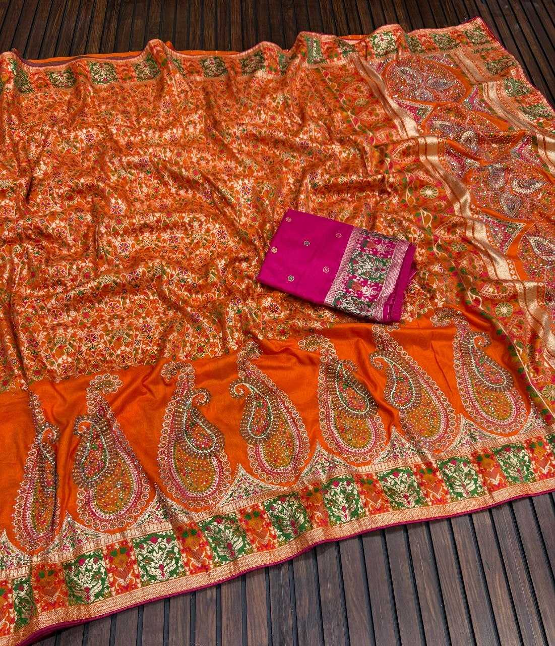 Orange saree with intricate patterns on a wooden surface