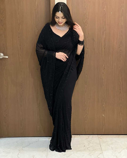 Woman wearing a black saree with a wooden door background