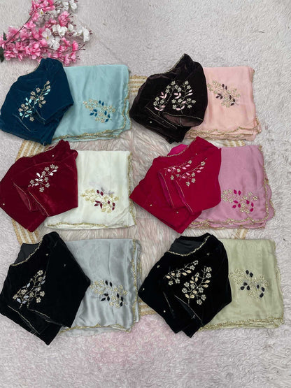 Nine folded embroidered dupattas in various colors including navy, light blue, black, pink, red, cream, and light green, arranged on a textured white surface with decorative pink flowers in the top left corner.