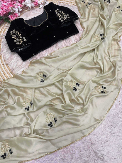 Beige saree with black blouse piece on a decorative background