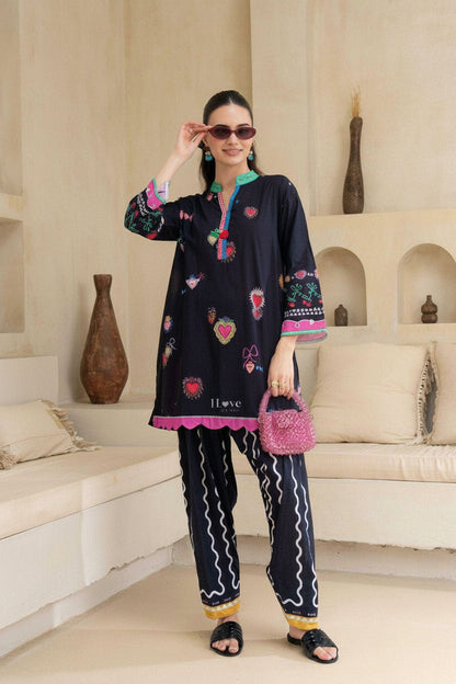 Woman wearing a black embroidered outfit in a living room setting