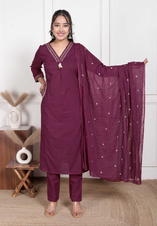 Woman wearing a purple traditional outfit with a matching dupatta in a room setting.