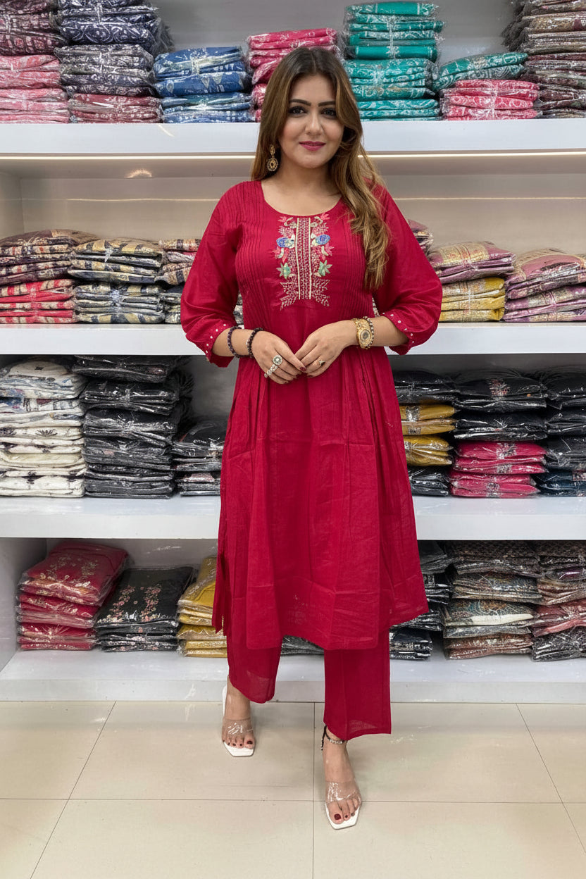 Woman in a red outfit standing in front of shelves with folded fabrics.