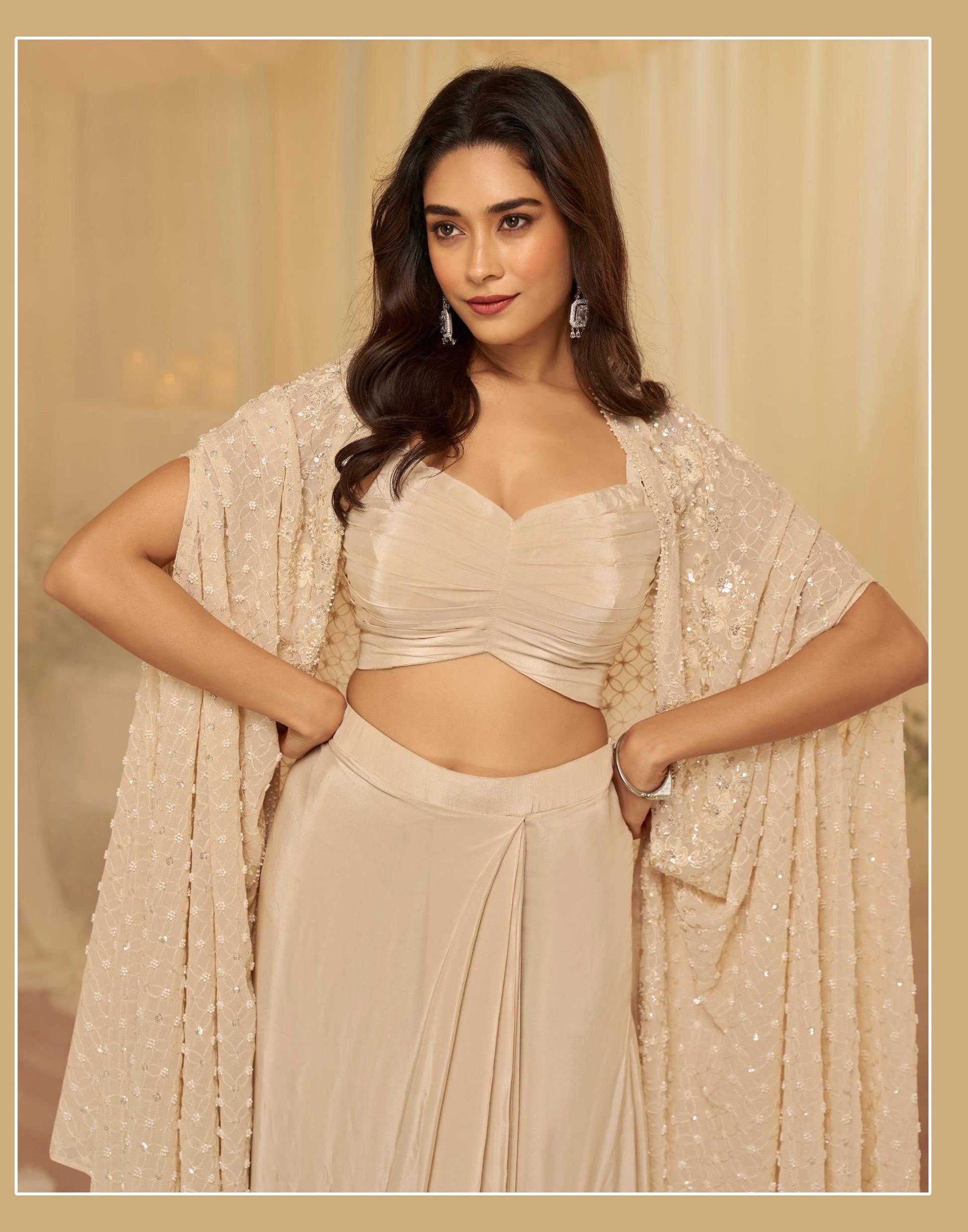 Woman in a beige traditional outfit with a matching shawl against a beige background