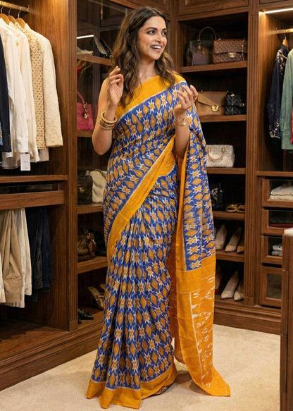 Woman wearing a blue and yellow saree in a clothing store.