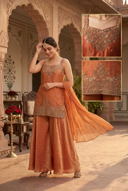 Woman in an orange traditional outfit with intricate detailing in a decorative setting.